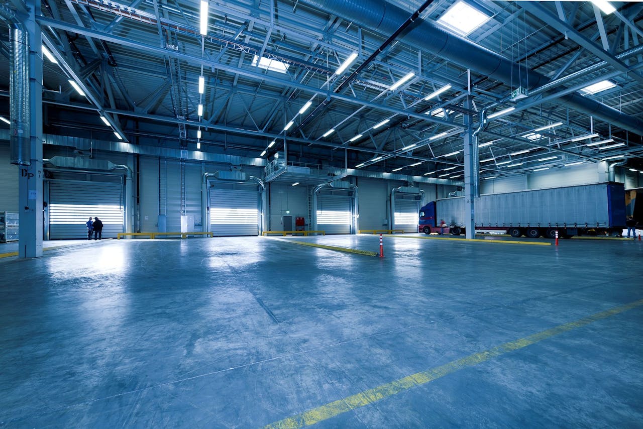 about-01 Large warehouse interior with docked truck, ideal for logistics and warehousing.