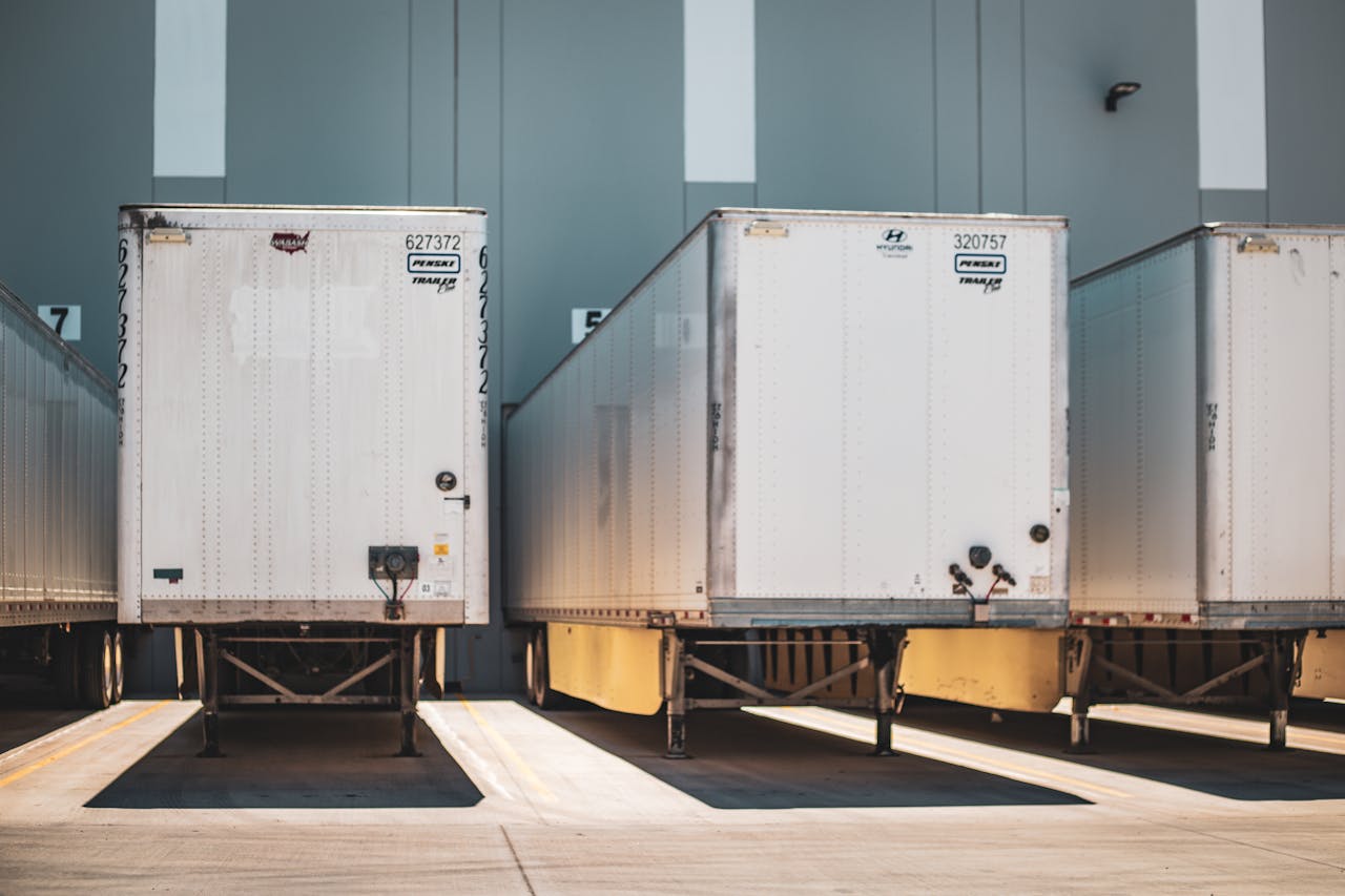 gallery-2 A row of freight trailers parked at a commercial loading dock, emphasizing transportation and logistics.